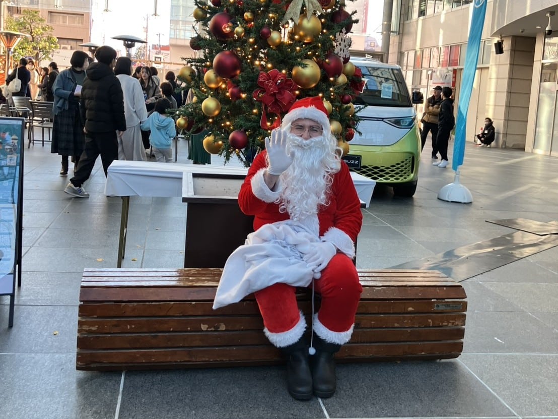 クリスマスツリーの前で出迎えるサンタクロース